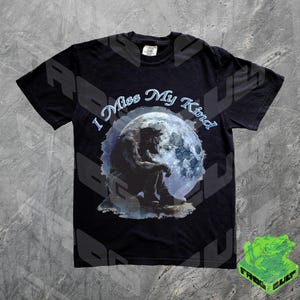 May include: Black t-shirt with a graphic of a werewolf sitting under a full moon. The text "I Miss My Kind" is printed on the shirt.