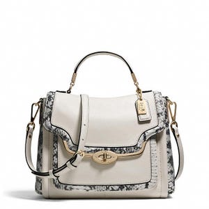May include: Cream-coloured leather handbag with a top handle and a detachable shoulder strap. The bag features a snakeskin pattern trim and gold-tone hardware, including a clasp closure and a small tag. The bag has a structured design.