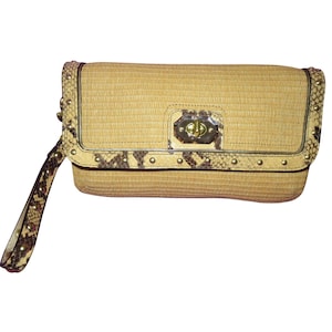 May include: A rectangular clutch with a woven straw body. The clutch features a flap closure with a gold-tone clasp and is accented with faux snakeskin trim and gold studs. A matching wrist strap is attached.