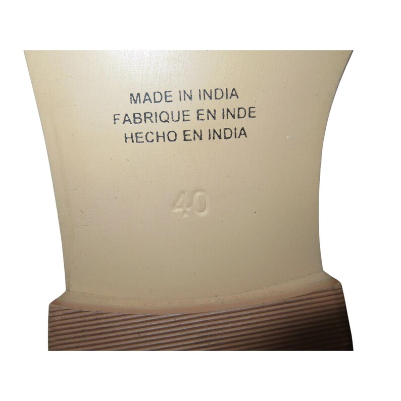 May include: Close-up of the sole of a shoe. The sole is a light beige color with the number 40 printed on it. The text "MADE IN INDIA, FABRIQUE EN INDE, HECHO EN INDIA" is also printed on the sole.