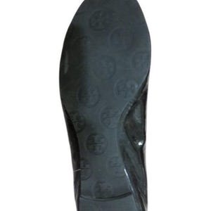 以下が含まれることがあります： 丸いつま先の黒い革製のバレエフラット。ソールにはロゴが入った円形の繰り返し模様があります。靴は光沢のある仕上がりです。