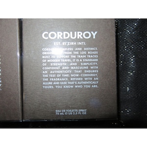 May include: A perfume box with the word "CORDUROY" in white lettering. The box also includes the text "EAU DE TOILETTE SPRAY 75 ml e US 2.5 fl oz". The box is a dark brown colour.