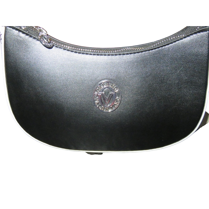 May include: Black crescent-shaped handbag with a silver zipper and a silver emblem. The bag has a white trim along the bottom edge. The emblem is a circular design with the letter "V" in the center.