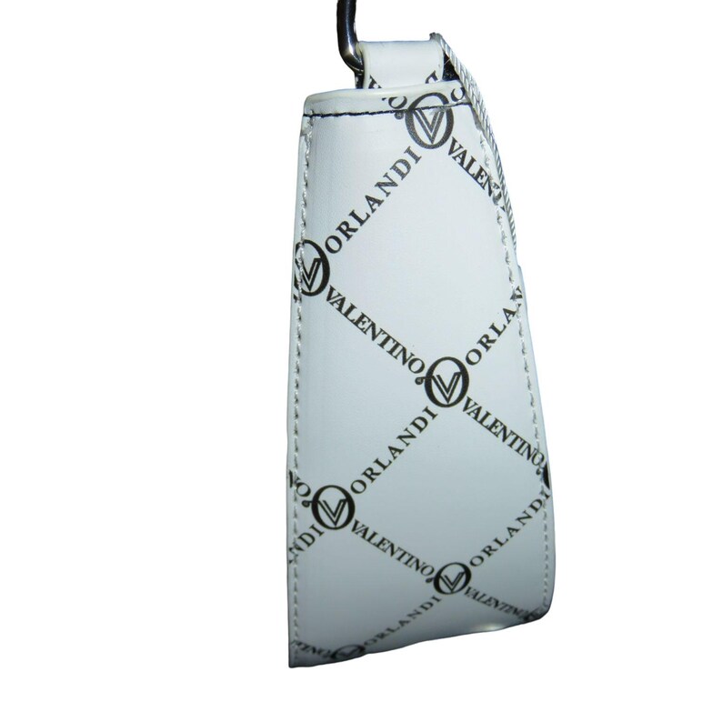 May include: White handbag with a repeating black pattern of the words "VALENTINO ORLANDI" and a logo. The bag has a silver-colored metal handle and a white strap. The bag is made of a smooth, shiny material.
