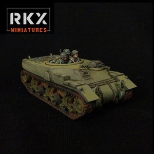 Peut inclure: Un modèle de char militaire vert avec deux figurines à l'intérieur de la tourelle. Le char est doté d'une conception détaillée avec des chenilles, des roues et un canon. Les figurines portent des uniformes militaires et des casques. Le modèle est peint dans un motif de camouflage réaliste.