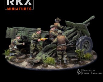 Può includere: Un diorama in miniatura con quattro soldati dipinti in uniformi verde oliva che manovrano un cannone d'artiglieria verde. Un soldato tiene in mano un proiettile giallo. La scena è posta su una base testurizzata con erba e terreno fangoso.