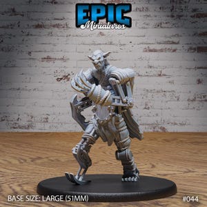 Op de afbeelding: Een grijs, gedetailleerd miniatuur van een goblin met mechanische benen en armen. De goblin houdt een wapen in zijn rechterhand. Het miniatuur staat op een ronde basis. Basisgrootte: Groot (51 mm). #044