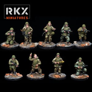Op de afbeelding: Miniatuurfiguren van soldaten in groene en camouflage uniformen, geposeerd op ronde bases met baksteen- en puindetails. De figuren houden wapens en uitrusting vast. Het "RKX MINIATURES" logo is zichtbaar.