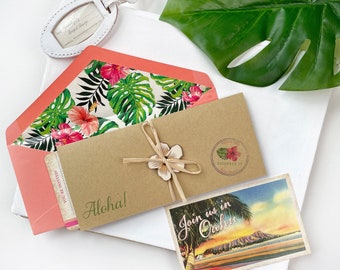 Könnte beinhalten: Eine tropische Hochzeitseinladung mit einem braunen Umschlag, einem rosa-grünen, floral gemusterten Innenumschlag und einer Postkarte mit dem Text "Join us in Oahu".