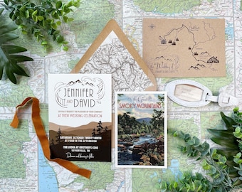 Può includere: Un set di partecipazioni di nozze con una carta bianca con grafiche di montagne e testo per Jennifer e David, una carta marrone, una cartolina delle Smoky Mountains e un'etichetta per bagagli bianca, disposti su uno sfondo di mappa.