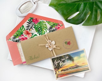 May include: A kraft paper envelope tied with twine and a wooden flower, featuring the text Aloha! and a circular stamp with a hibiscus. It includes a coral envelope with a tropical leaf and hibiscus liner, and a postcard with the text Join us in Oahu.