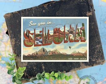 Può includere: Una cartolina rettangolare con il testo See you in... SEDONA in grandi lettere riempite con immagini di paesaggi di rocce rosse, cactus e fiori. La cartolina include una mongolfiera e il testo ELSIE + ADAM - 08.01.26.