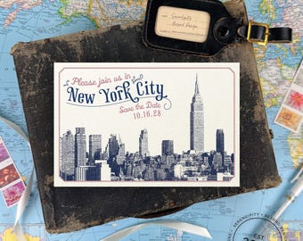 May include: A rectangular Save the Date card featuring a dark blue New York City skyline illustration, the text Please join us in New York City, and the date 10.16.28 in red and blue ink on a white background with a thin red border frame.