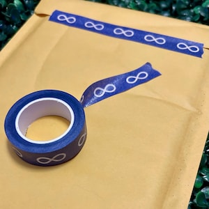 May include: A roll of blue washi tape with white infinity symbols on a brown paper envelope.