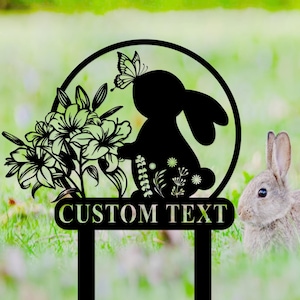 May include: Black metal garden stake with a silhouette of a bunny rabbit, flowers, and a butterfly. The stake has a space for custom text that reads "CUSTOM TEXT".