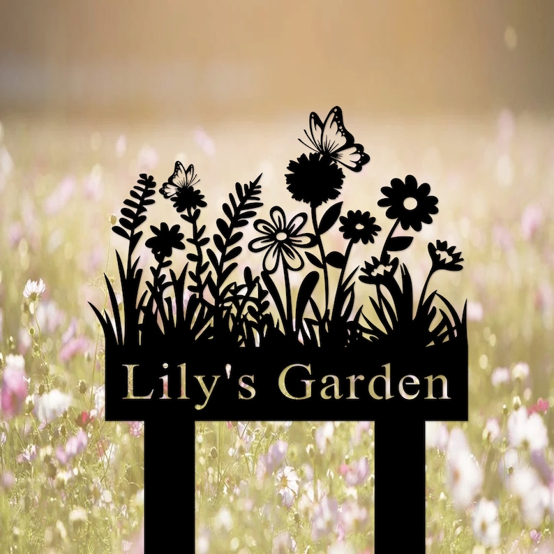 Puede incluir: Letrero de jard&iacute;n de metal negro con una silueta de flores, mariposas y hierba. El letrero dice "Lily's Garden".