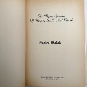 May include: Open book with text: "The Mystic Grimoire Of Mighty Spells And Rituals" by Frater Malak. The book's pages are off-white with a slightly aged appearance. The publisher is Parker Publishing Company, Inc., West Nyack, N.Y.