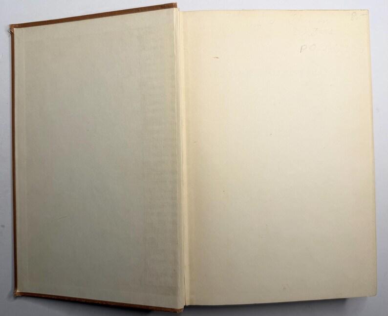 May include: An open book with a brown cover and off-white pages. The binding is visible, and the pages are slightly yellowed with age. Handwritten text is visible on the right page.