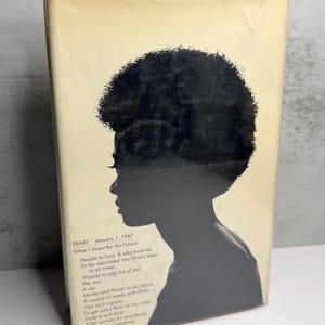 May include: A book cover with a black silhouette of a person with an afro. The cover is a light beige colour with text that includes "DIARY January 1, 1967" and a list of aspirations.