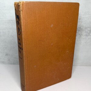 May include: A vintage hardcover book with a tan cover. The book's spine features the title "The Black Nation's Tilly" and a small illustration. The cover shows some wear and tear, with visible spots and discoloration.