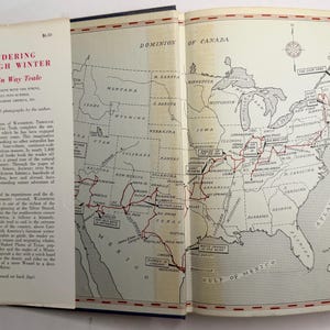 May include: An open book with the title "Wandering Through Winter" by Edwin Way Teale. The left page displays text, while the right page features a detailed map of the United States with a red route marked across it.