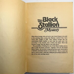 May include: An open book with the title "The Black Stallion Mystery" in a stylized font. The text describes a story about young Alec Ramsay and his horse, the Black Stallion, and a mystery surrounding the horse's sire.