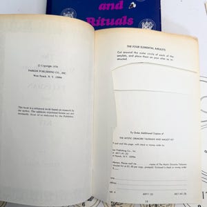 May include: Open book with the title "of Mighty Spells and Rituals" in pink and blue. The pages show text about elemental amulets and ordering additional copies of a kit. Copyright 1976 by Parker Publishing Co., Inc.
