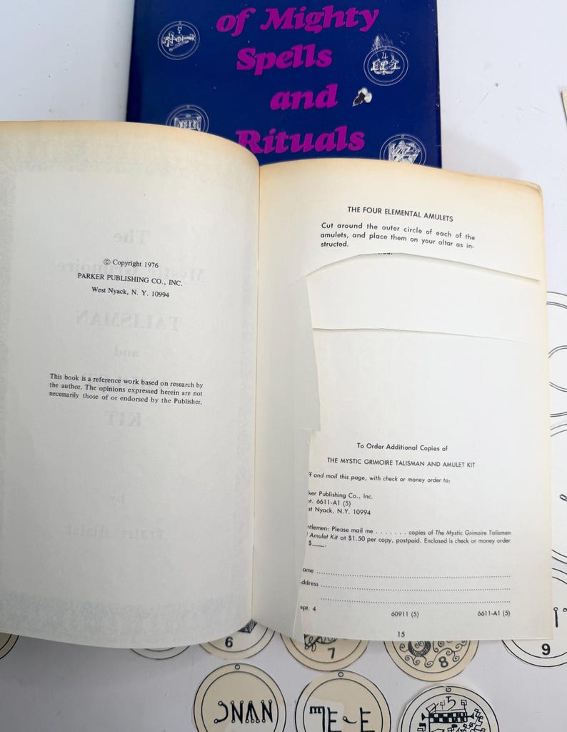 May include: Open book with the title "of Mighty Spells and Rituals" in pink and blue. The pages show text about elemental amulets and ordering additional copies of a kit. Copyright 1976 by Parker Publishing Co., Inc.