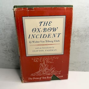 May include: A vintage copy of "The Ox-Bow Incident" by Walter Van Tilburg Clark. The book features a red cover with white text and a decorative illustration. The spine is green. The book is from The Press of The Readers Club, a classic novel.