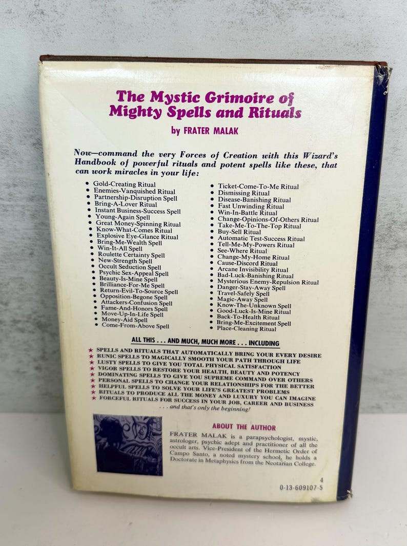 May include: The Mystic Grimoire of Mighty Spells and Rituals by Frater Malak. The book cover lists various spells and rituals, including those for wealth, love, and success. The cover is white with black and purple text.