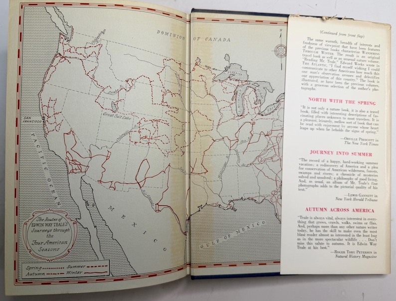 May include: Open book with a map of North America and Mexico, featuring red lines indicating routes. The text "The Routes of Edwin Way Teale's Journeys through the Four American Seasons" is visible. A bookmark with text is inserted.