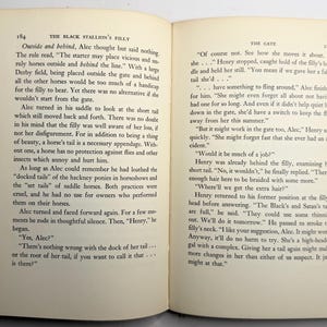 May include: Open book with text on aged paper. The text is divided into two columns, with the title "THE BLACK STALLION'S FILLY" on the left page and "THE GATE" on the right. The pages are slightly yellowed.