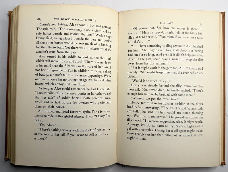 May include: Open book with text on aged paper. The text is divided into two columns, with the title "THE BLACK STALLION'S FILLY" on the left page and "THE GATE" on the right. The pages are slightly yellowed.