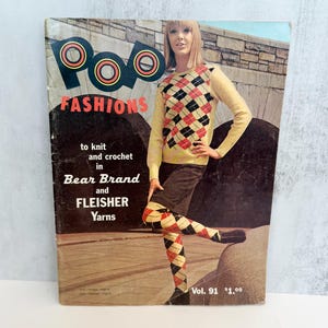 May include: A vintage Pop Fashions magazine, Volume 91, featuring a person wearing a cream-colored sweater and matching tights with a black, red, and cream argyle pattern. The cover includes the text to knit and crochet in Bear Brand and Fleisher Yarns.