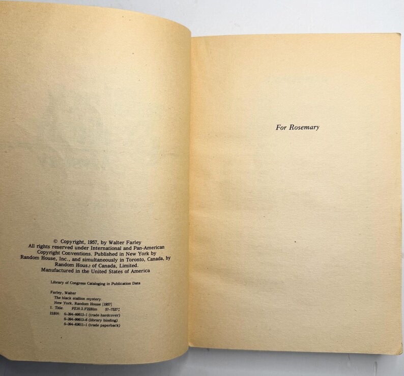 May include: Open book pages with text. The left page has copyright information, including the author's name and publisher. The right page reads "For Rosemary". The pages are aged with a yellowed tone.