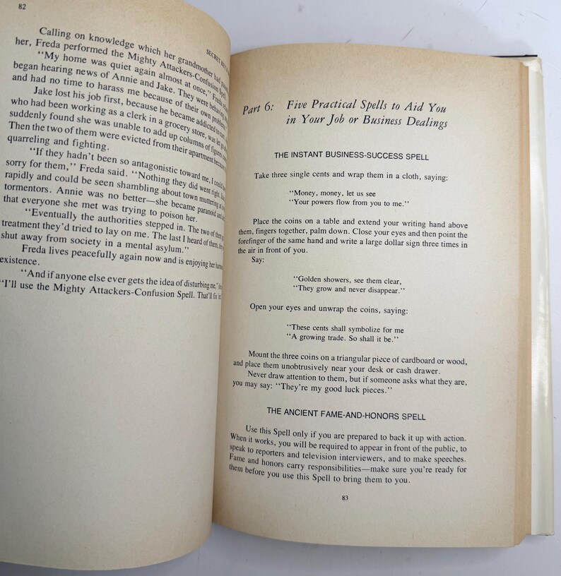 May include: Open book with text on the pages. The text includes the title "Five Practical Spells to Aid You in Your Job or Business Dealings." The text describes spells for business success and fame.