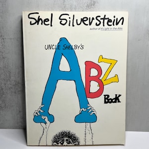 May include: A vintage copy of "Uncle Shelby's ABZ Book" by Shel Silverstein. The cover features large, colorful letters: a blue A, a red B, and a yellow Z. The title and author's name are in black.