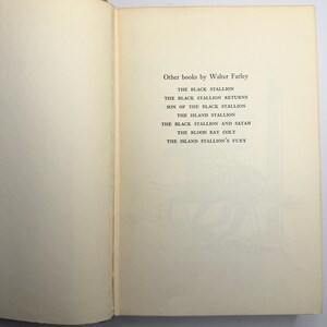 May include: Open book page with a list of titles by Walter Farley. The titles include "The Black Stallion," "The Black Stallion Returns," and "Son of the Black Stallion." The page has a cream-colored background with black text.