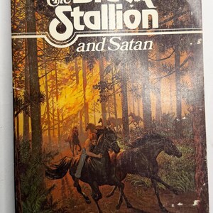 May include: Vintage paperback book cover for "The Black Stallion and Satan" by Walter Farley. The cover features a forest scene with horses and riders, with the title in large white letters. The book is a classic.