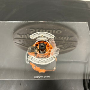 Peut inclure: Un gros plan sur une fraise de toupie fix&eacute;e &agrave; une base de toupie en acrylique transparente. La base porte l'inscription "Compact Router Base".