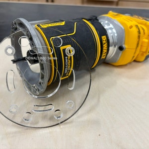 May include: A yellow and black DeWalt 600 Series router with a clear plastic template. The router has a brushless motor and a variable speed control.