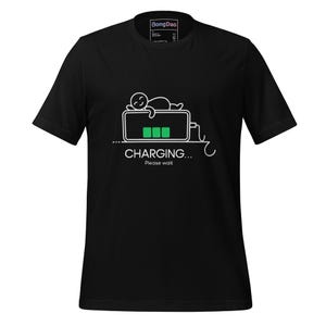 May include: Black t-shirt with a white graphic of a person lying on a charging phone. The phone shows three green charging bars and the text "CHARGING... Please wait."