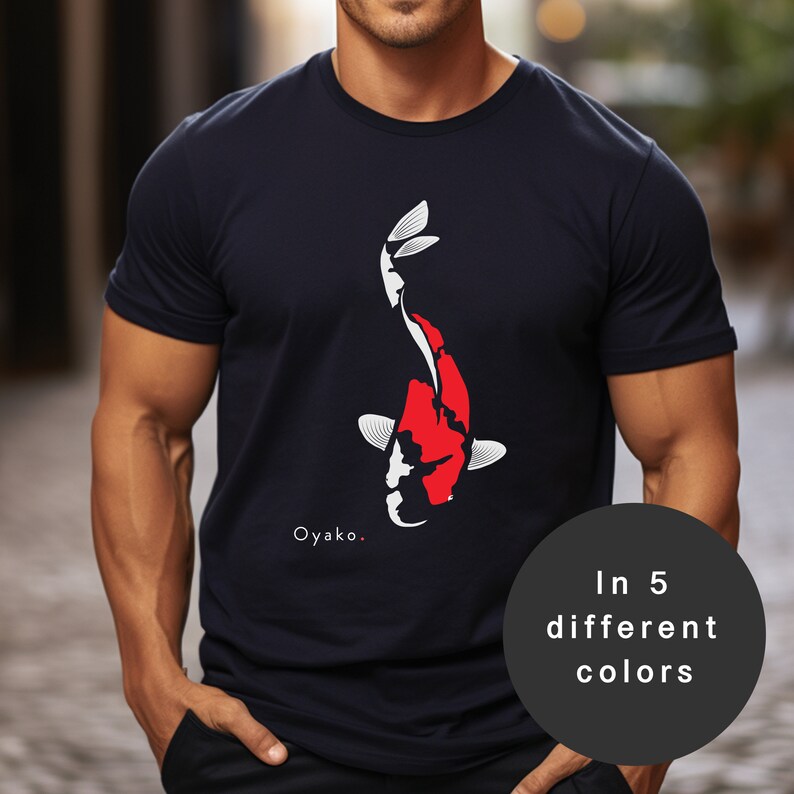 May include: A navy blue t-shirt featuring a white and red koi fish graphic. The text "Oyako." is printed below the fish. The t-shirt is available in five different colours.