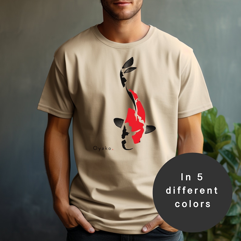 May include: A beige t-shirt featuring a black and red koi fish graphic. The text "Oyako." is printed below the fish. The t-shirt is available in five different colours.