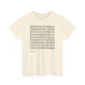 May include: Cream-colored t-shirt featuring a square pattern of vertical black lines. The shirt has short sleeves and a crew neck. The word "Oyako" is printed in black at the bottom of the design. A casual, everyday tee.