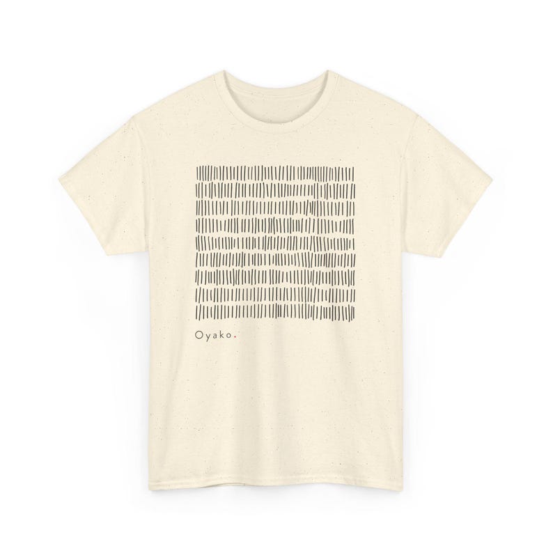 May include: Cream-colored t-shirt featuring a square pattern of vertical black lines. The shirt has short sleeves and a crew neck. The word "Oyako" is printed in black at the bottom of the design. A casual, everyday tee.
