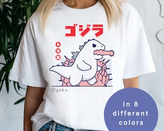 May include: White t-shirt with a cartoon Godzilla graphic in blue and red. The text "ゴジラ" is in red and the text "Oyakoo." is in black.