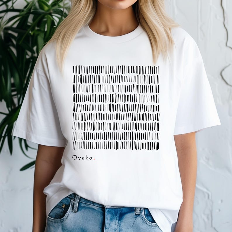 May include: White t-shirt featuring a black and white abstract design of vertical lines. The design is a square pattern. The word "Oyako." is printed in black with a red period at the end.