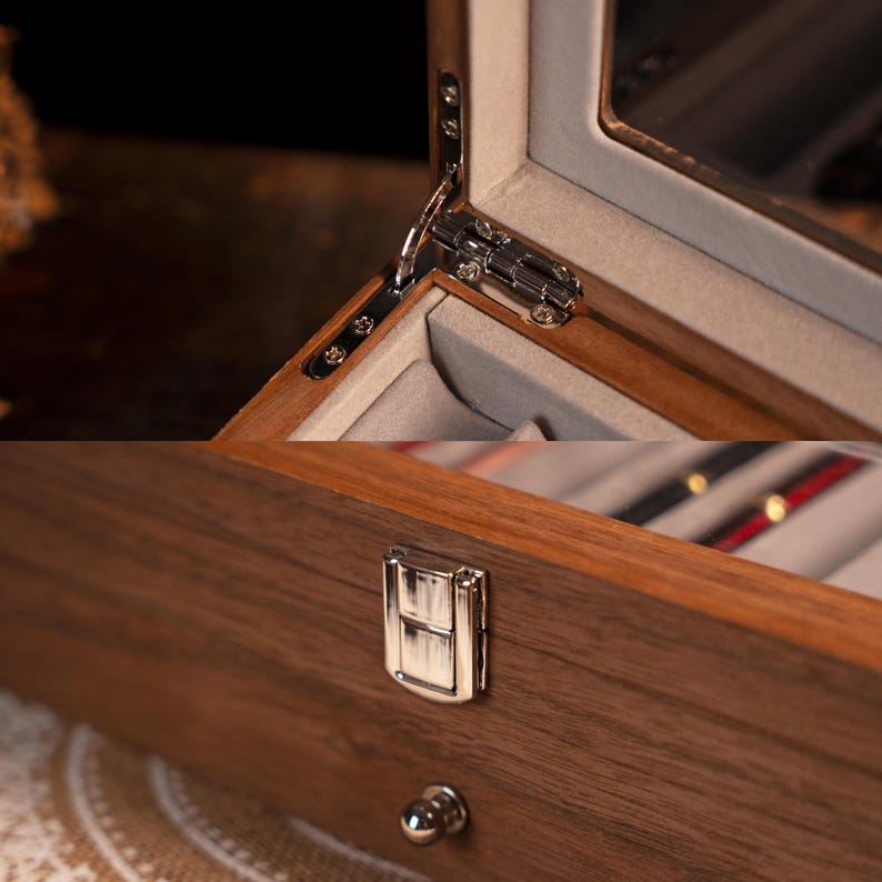 Może przedstawiać: Zbliżenie drewnianego pudełka na biżuterię ze szklanym wieczkiem. Pudełko posiada srebrny zawias i zapięcie. Wnętrze wyłożone jest jasnoszarą tkaniną. Drewno ma bogaty, ciemnobrązowy kolor.