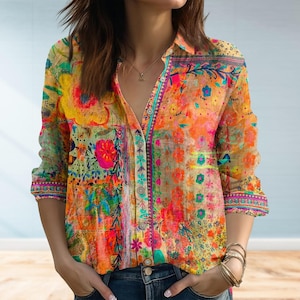 Pode incluir: Camisa abotoada de manga comprida com um padrão floral vibrante em tons de laranja, amarelo, rosa e verde. A camisa tem gola e um design de patchwork, criando uma estética boémia.
